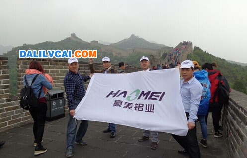 豪美鋁業(yè)優(yōu)秀員舉公司旗幟爬長城